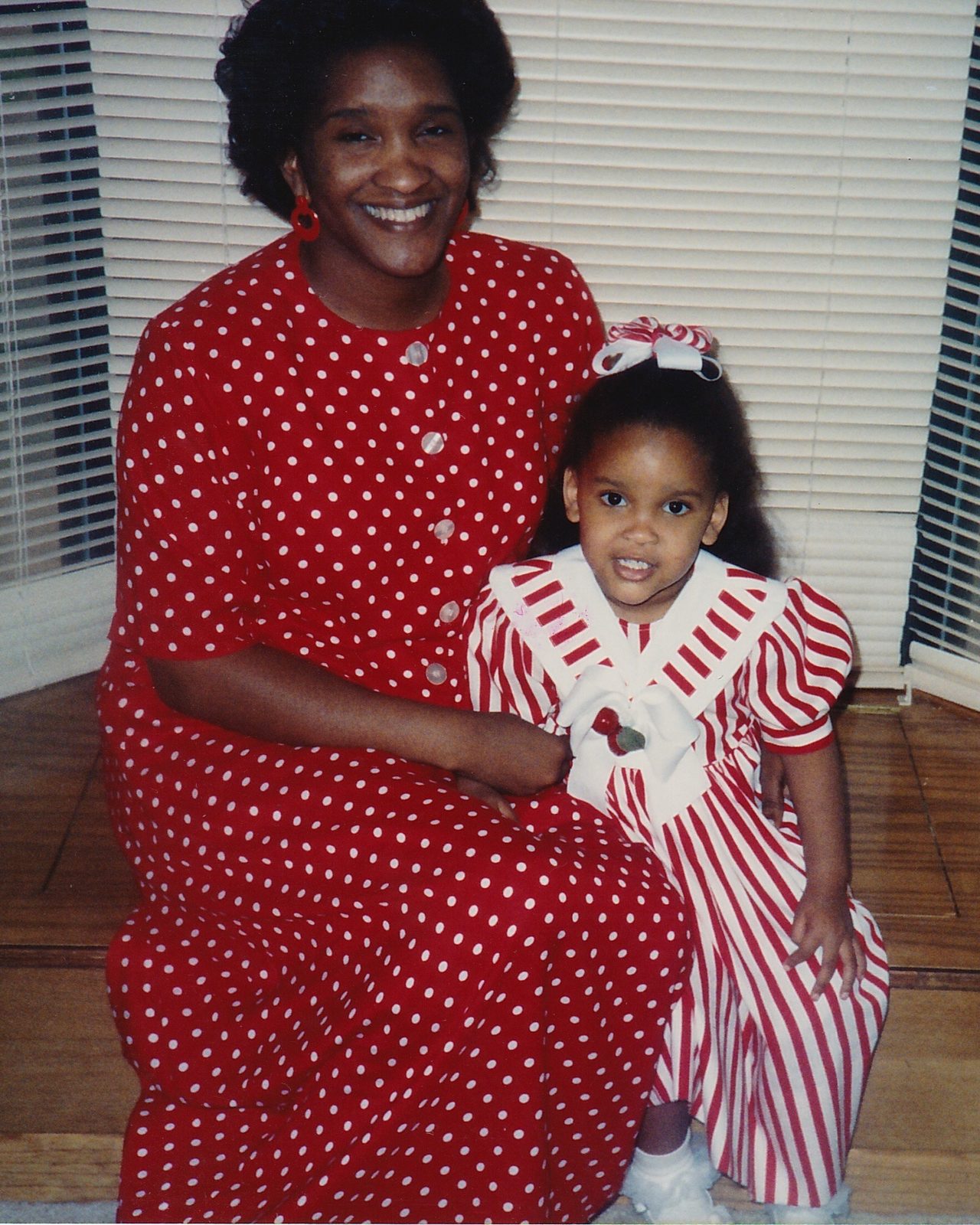 A mother in a red polka-dot dress with a little girl in red and white stripes